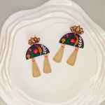 Handcrafted Blooming Lotus Tassel Earrings on a white ceramics plate, featuring vibrant flowers, tassels, and a purple half-moon base