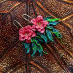 Handmade red hibiscus flower earrings with green vine leaves