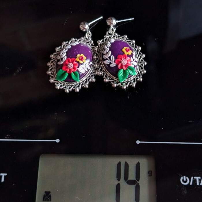 Radiant Floral Embrace Earrings with oxidized silver bezel, purple clay base, and detailed floral designs.