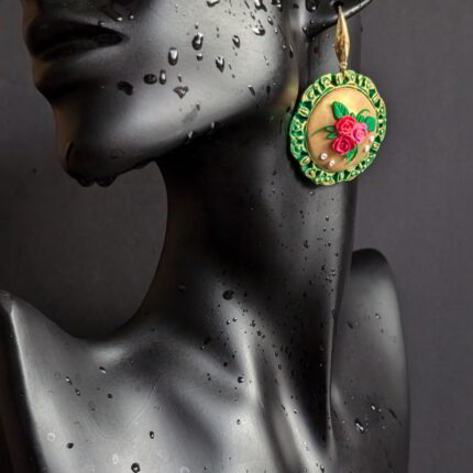 Handcrafted floral medallion earrings with green bezel and golden center adorned with roses and leaves.